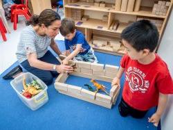 Teacher working with two children in children's center.